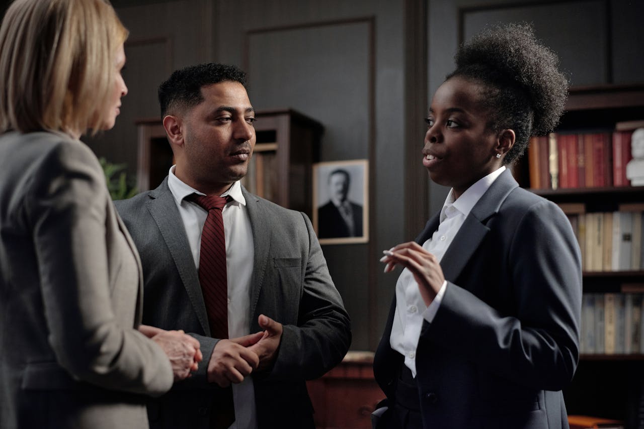 Group of diverse professionals discussing in office setting, highlighting teamwork and collaboration.
