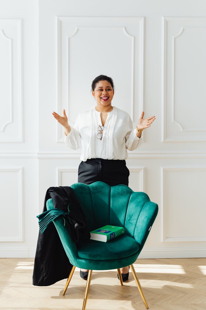 Confident woman standing in a bright office room, featuring a stylish green chair.