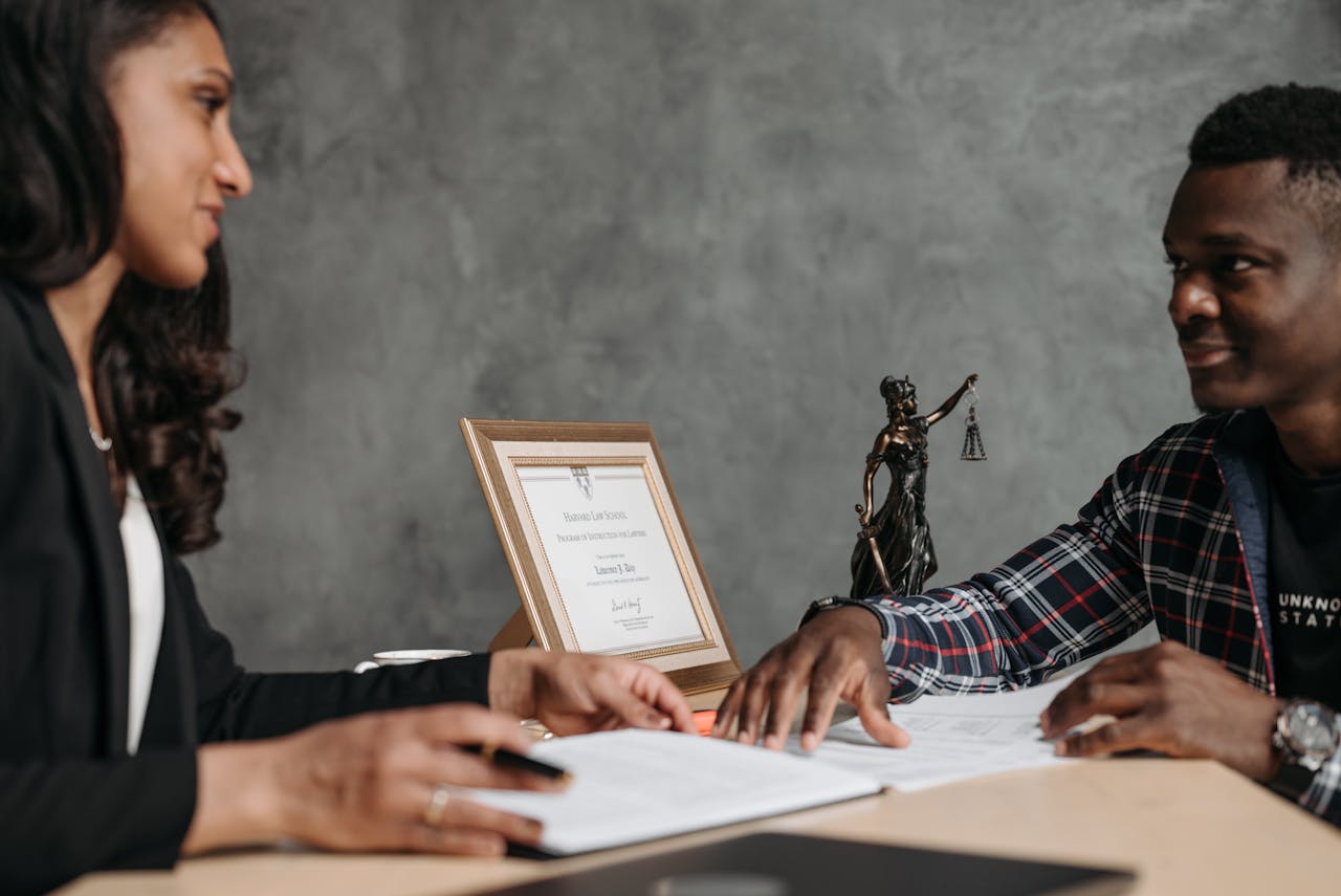 Two professionals engaged in a discussion over legal documents in an office setting.
